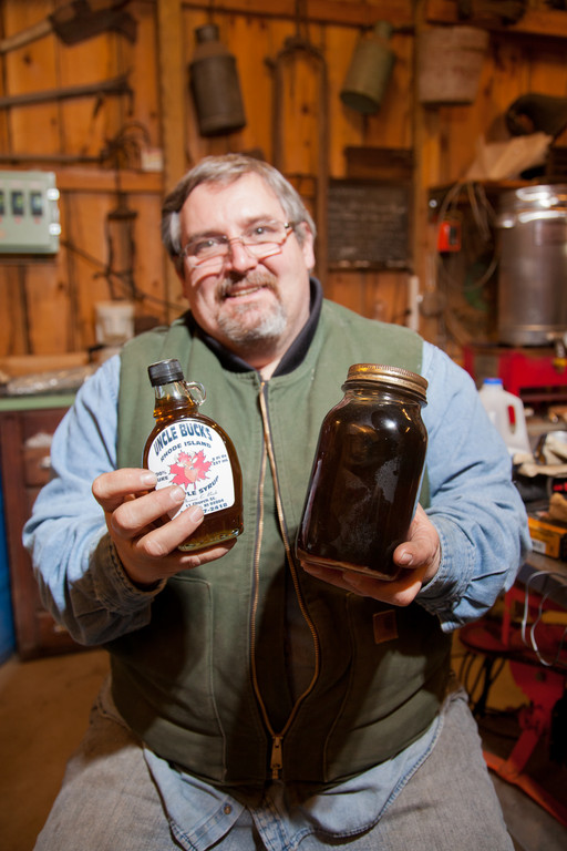 Uncle Buck holds a jar of the first batch of maple syrup he ever made; he's saving it to pass down to the next generation