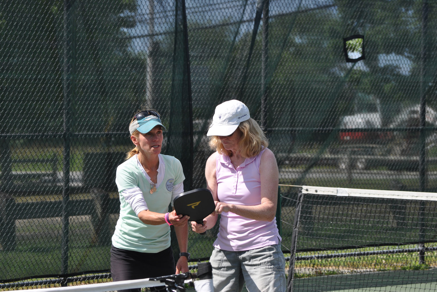 Ocean State Pickleball founder Kara Biller instructs a player on using pickleball’s broad, flat paddle