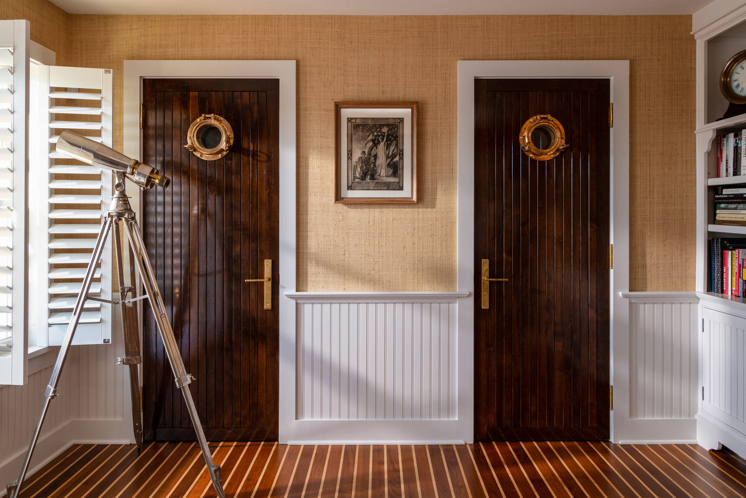 Grass-woven walls, custom lacquered teak doors with antique portholes, and teak and holly floors add up to traditional chart room style