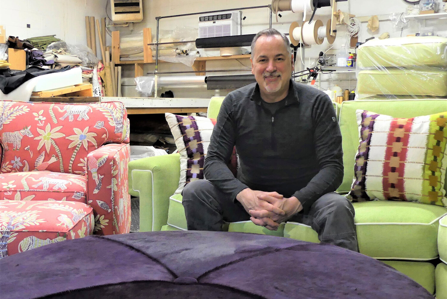 Gerry Emin sits among the pieces of one of his shop’s latest projects